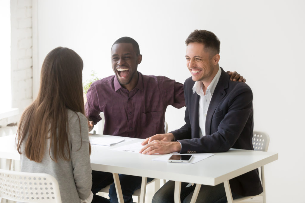 Hr managers laughing at funny humor joke during job interview talking to woman applicant.